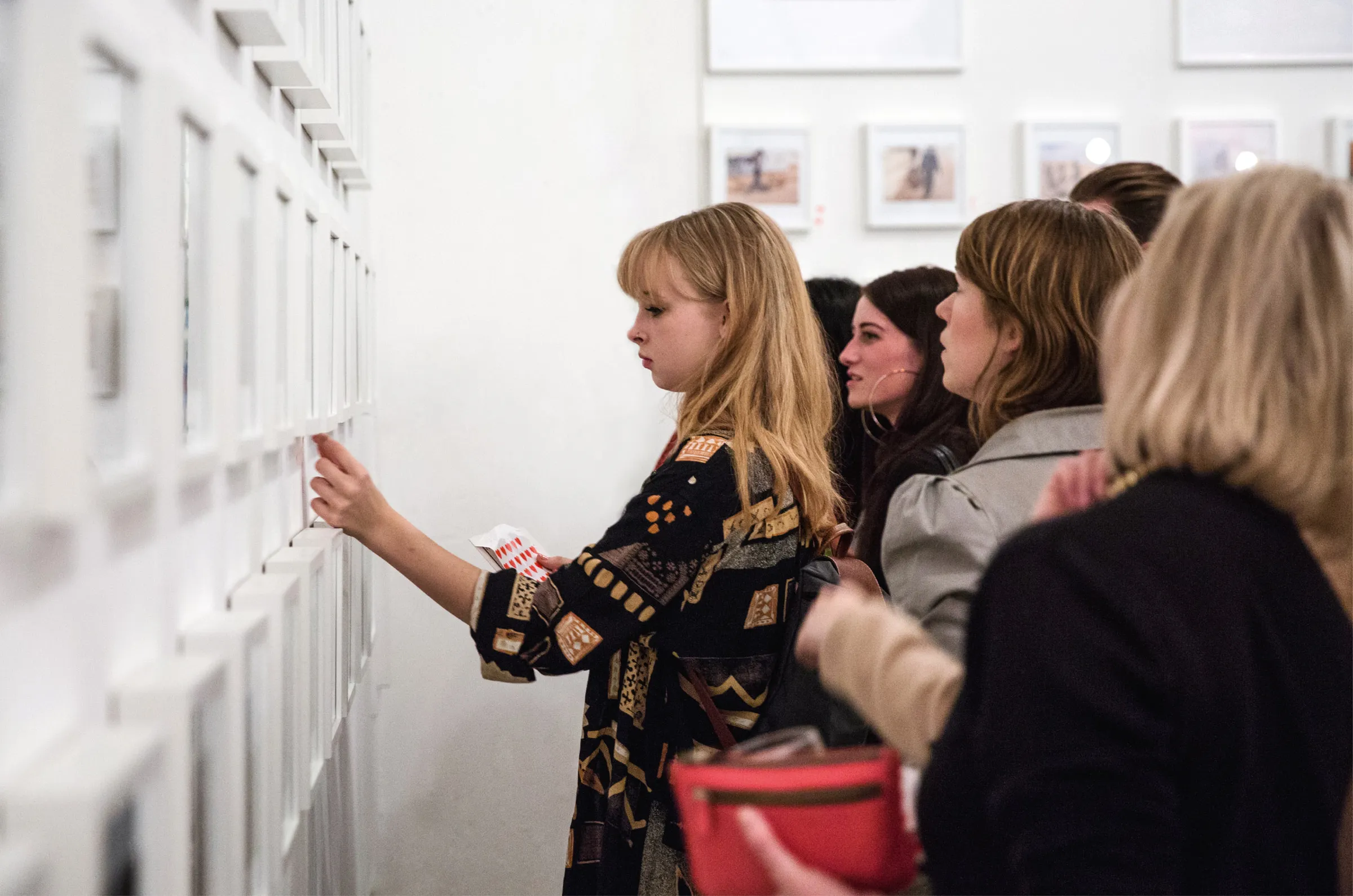 A visitor pressing a heart sticker beside a photograph she liked